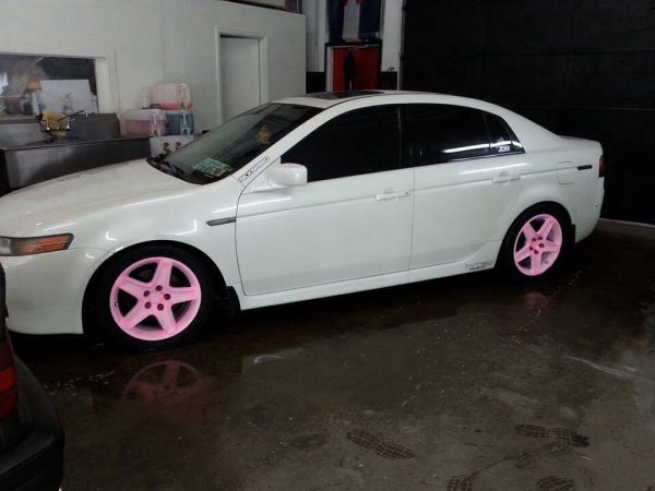 Car with the pink to orange glow in the dark wheels in the light.